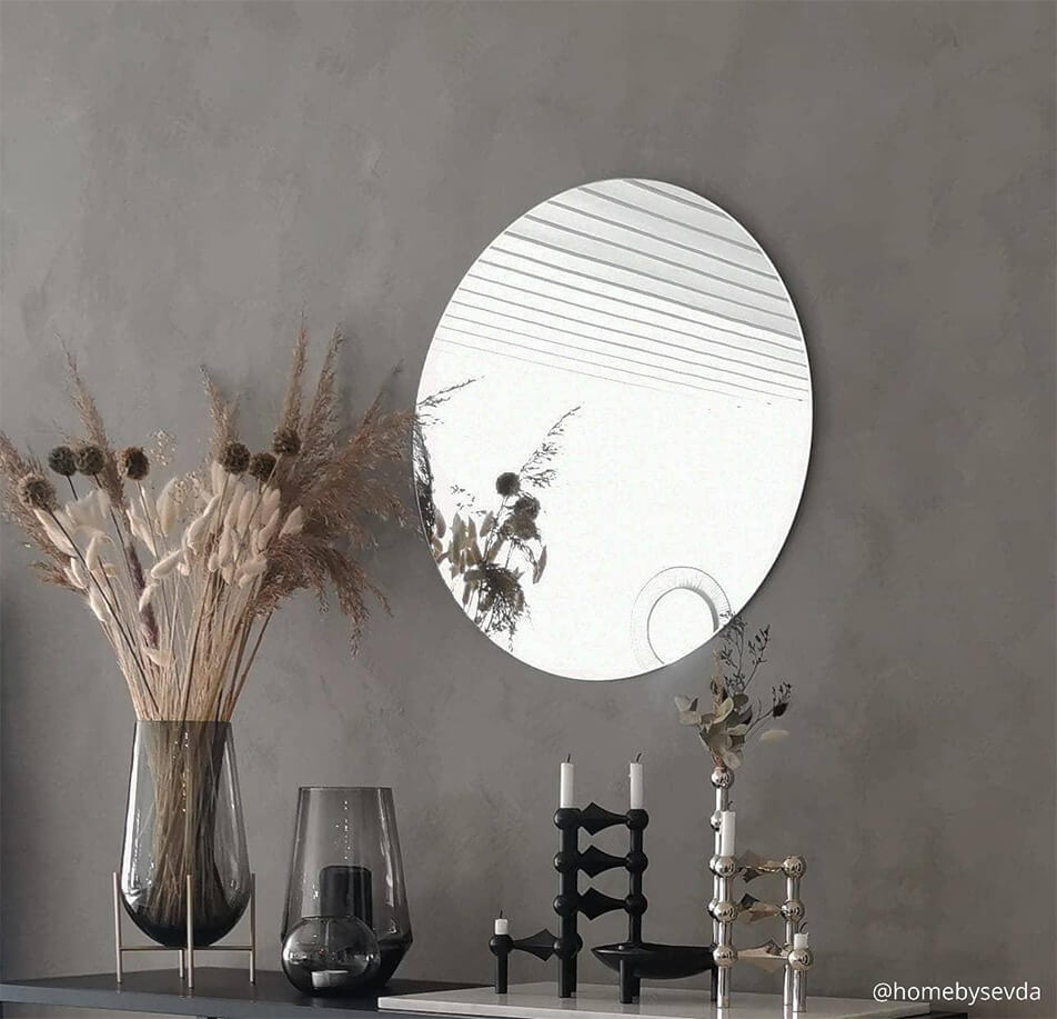 Miroir rond sur mur gris